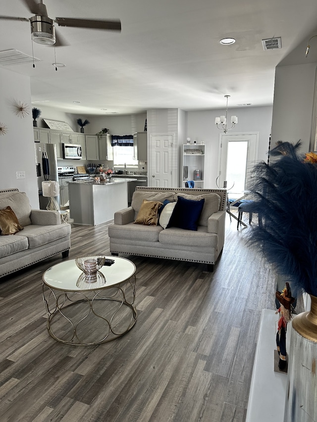 living room featuring dark hardwood / wood-style floors and ceiling fan with notable chandelier