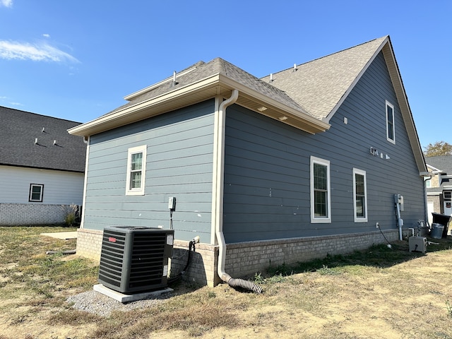 view of side of home with central air condition unit