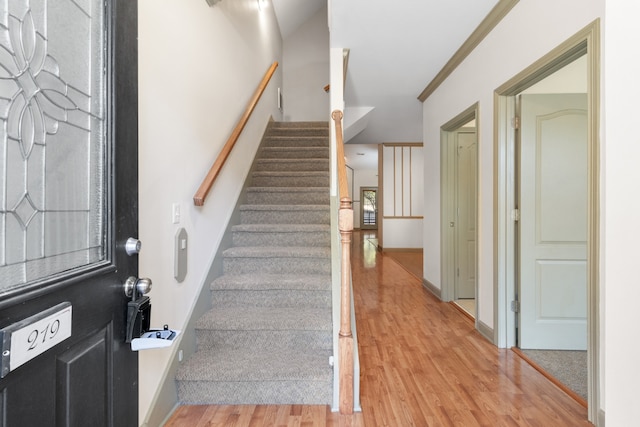 foyer with ornamental molding and light wood-type flooring