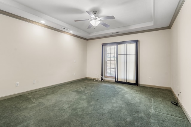 carpeted spare room with ornamental molding, a tray ceiling, and ceiling fan