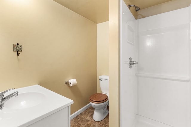 bathroom with toilet, vanity, and a shower