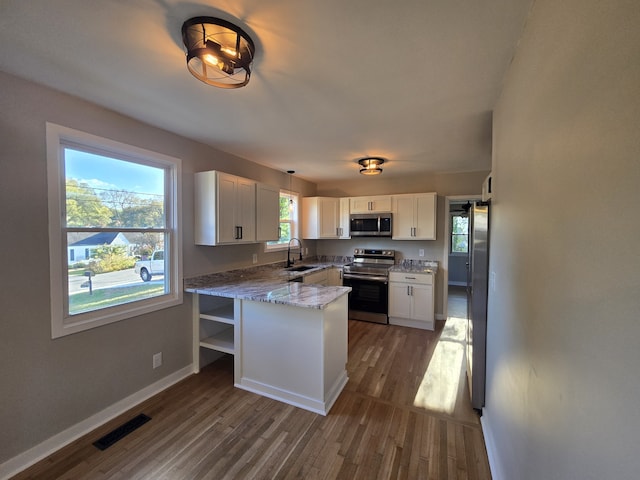 kitchen featuring sink, dark wood-type flooring, appliances with stainless steel finishes, light stone countertops, and white cabinets