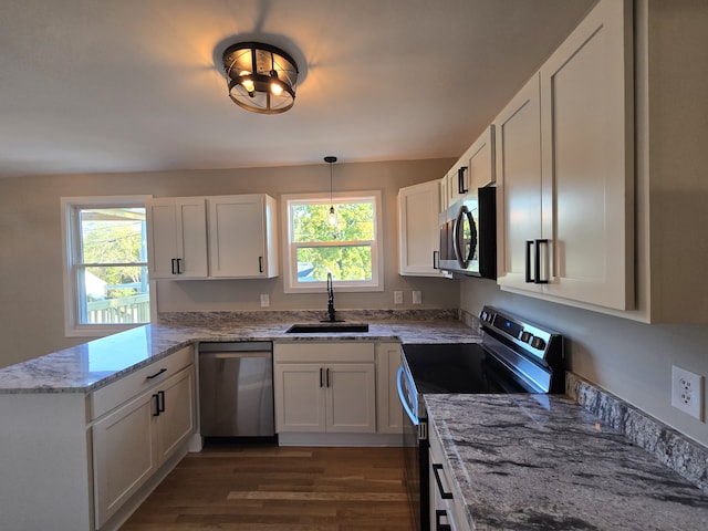 kitchen with pendant lighting, sink, white cabinetry, stainless steel appliances, and light stone countertops