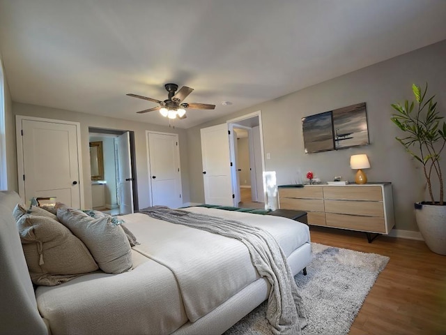 bedroom with ensuite bath, dark hardwood / wood-style floors, and ceiling fan