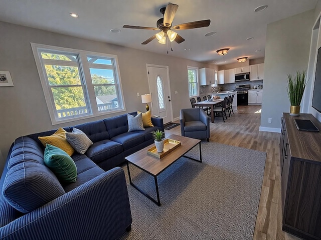 living room featuring plenty of natural light, light hardwood / wood-style floors, and ceiling fan