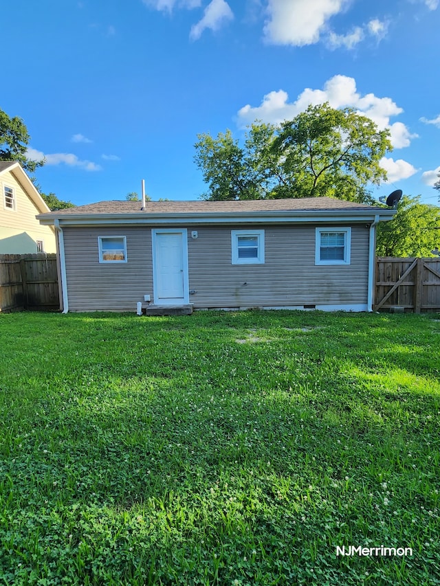 rear view of property with a lawn