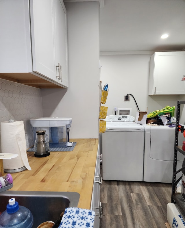 laundry area with washer and clothes dryer, dark hardwood / wood-style flooring, cabinets, and ornamental molding