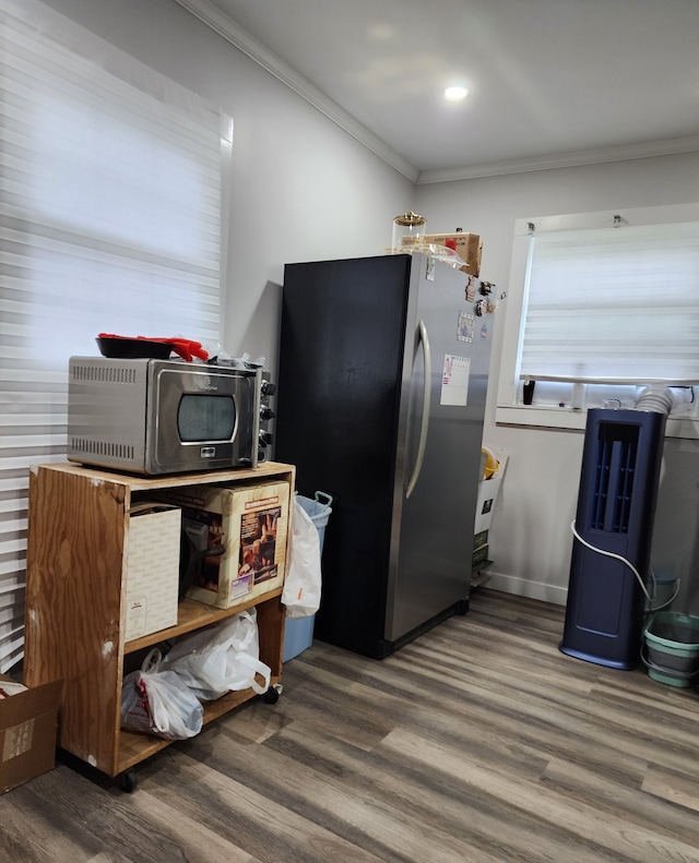 kitchen with dark hardwood / wood-style flooring, stainless steel refrigerator, and crown molding