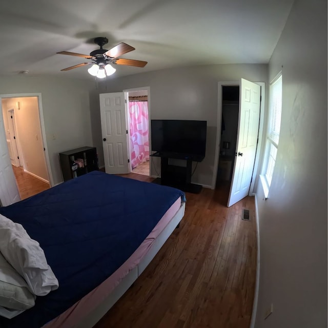 bedroom with ensuite bathroom, ceiling fan, dark hardwood / wood-style floors, and a closet