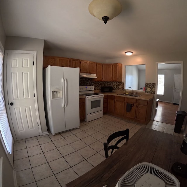 kitchen with backsplash, white appliances, sink, and light tile patterned floors