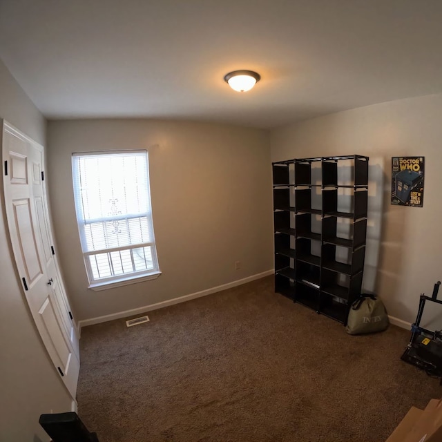 unfurnished room featuring dark carpet