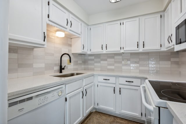 kitchen featuring white appliances, backsplash, white cabinetry, and sink