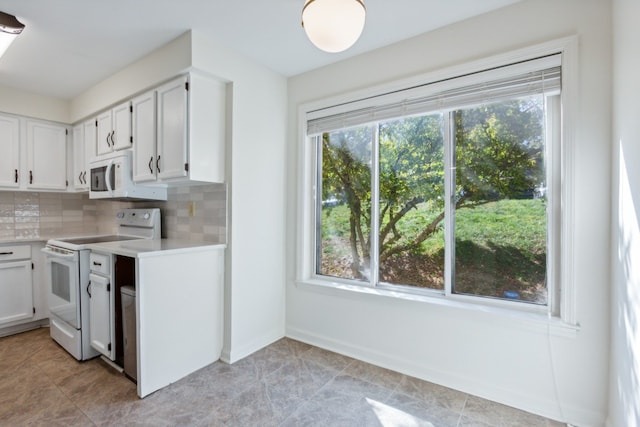 kitchen featuring white cabinets, decorative backsplash, white appliances, and a healthy amount of sunlight