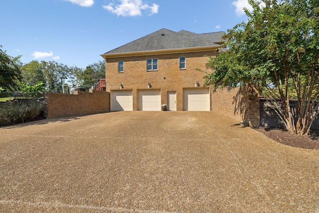2971 Spanntown Rd, Arrington, TN 37014 - rear view of house with an attached garage, concrete driveway, fence, and brick siding