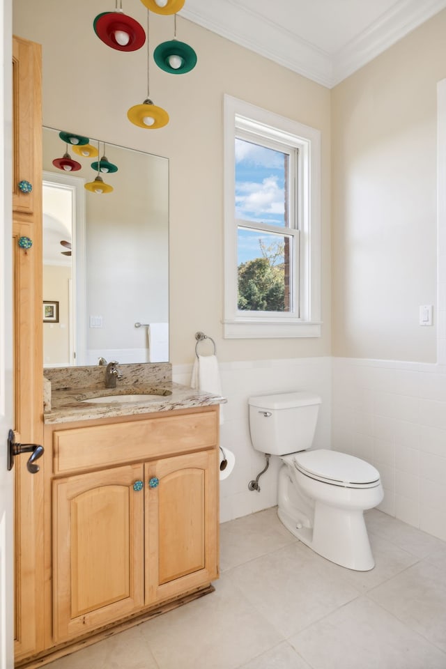 bathroom with tile walls, tile patterned flooring, ornamental molding, vanity, and toilet