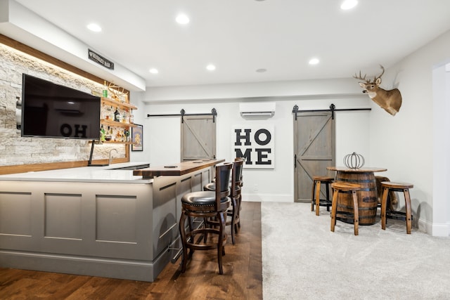 bar featuring a wall unit AC and a barn door