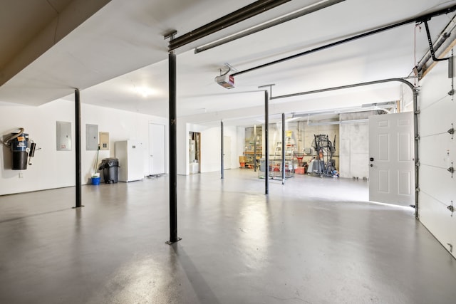 garage with a garage door opener and electric panel