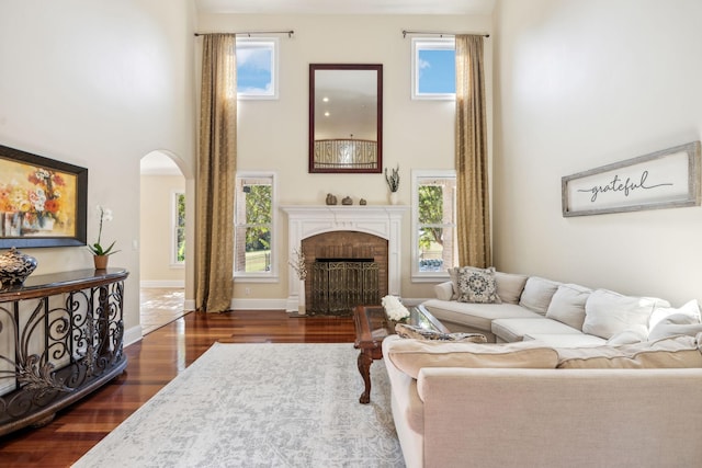 2971 Spanntown Rd, Arrington, TN 37014 - living room with a high ceiling, dark wood-style floors, arched walkways, a brick fireplace, and plenty of natural light