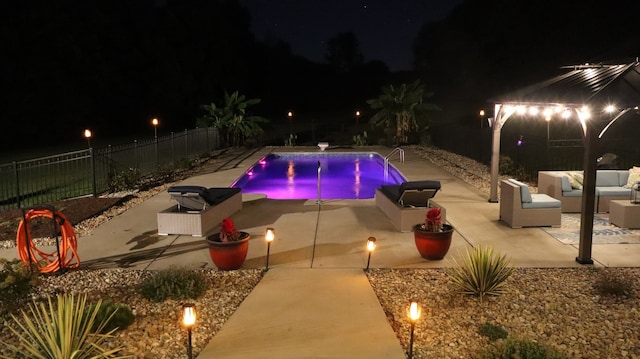 pool at twilight with an outdoor living space and a patio area