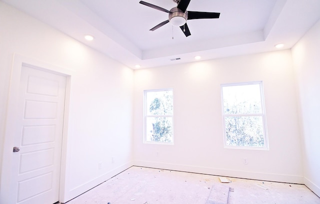 empty room with a tray ceiling and ceiling fan