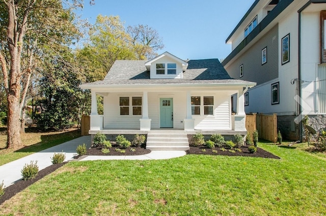 view of front of home with covered porch and a front lawn