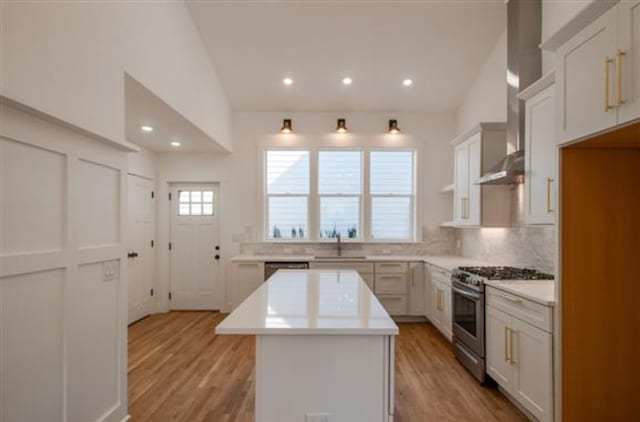 kitchen featuring white cabinetry, high end stainless steel range, lofted ceiling, and a kitchen island