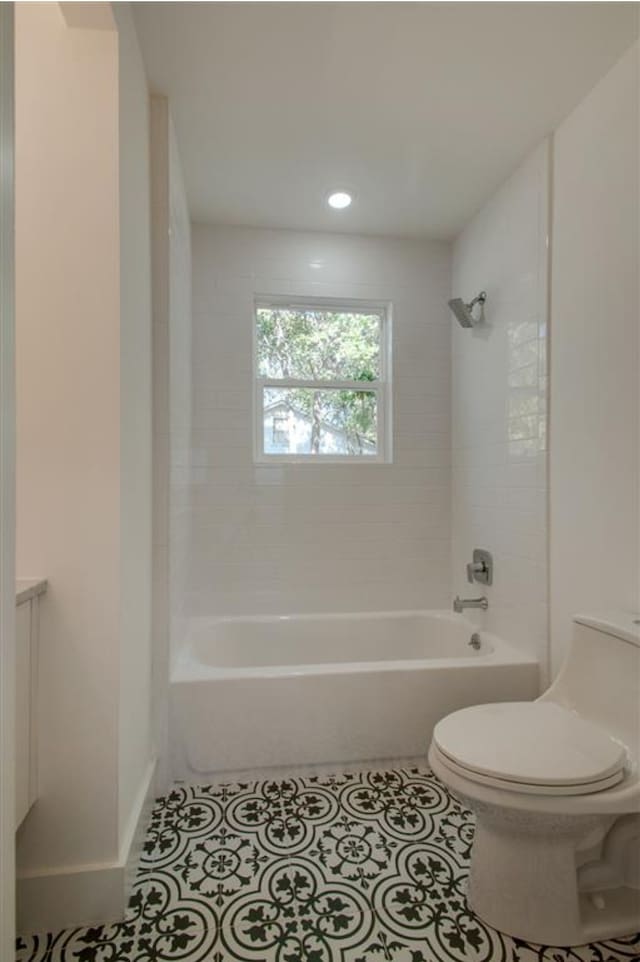 full bathroom featuring toilet, tiled shower / bath, vanity, and tile patterned flooring