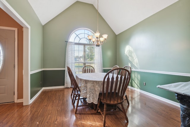 dining space with a notable chandelier, hardwood / wood-style floors, and high vaulted ceiling