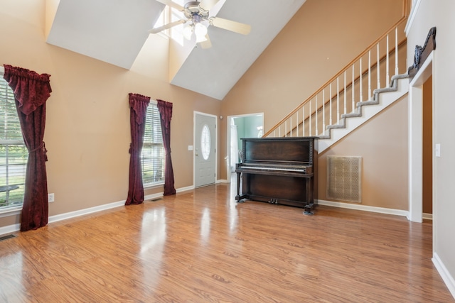 foyer featuring light hardwood / wood-style floors, high vaulted ceiling, and ceiling fan