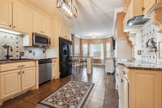 kitchen featuring appliances with stainless steel finishes, dark tile patterned floors, dark stone countertops, crown molding, and sink