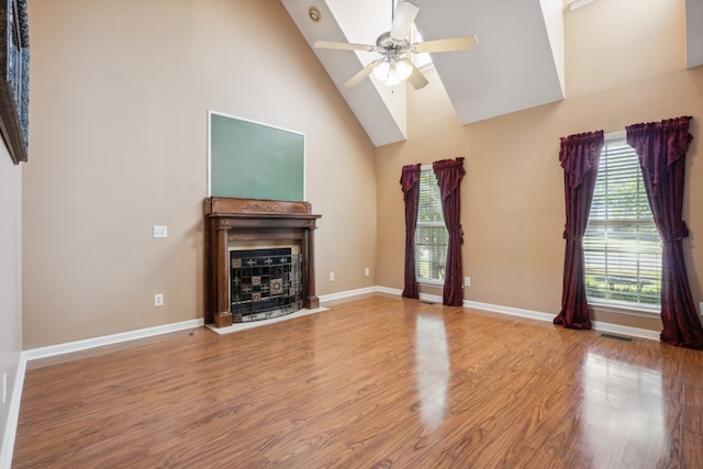 unfurnished living room featuring hardwood / wood-style flooring, high vaulted ceiling, and ceiling fan