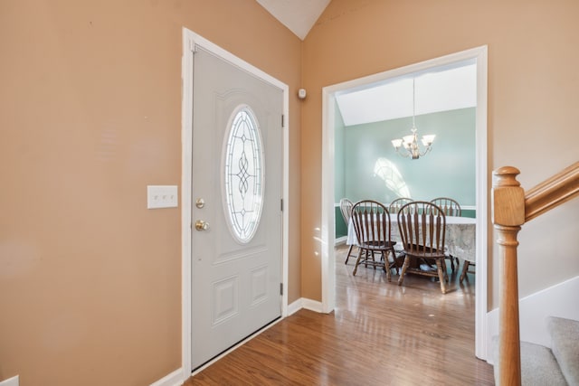 entrance foyer with an inviting chandelier, lofted ceiling, and wood-type flooring