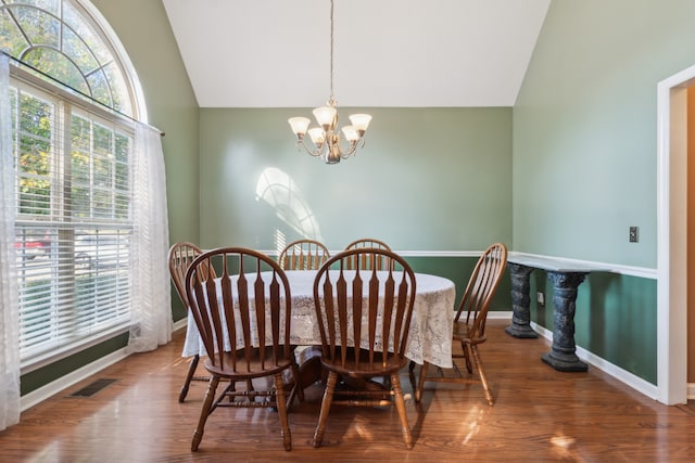 dining space with lofted ceiling, a chandelier, and hardwood / wood-style flooring