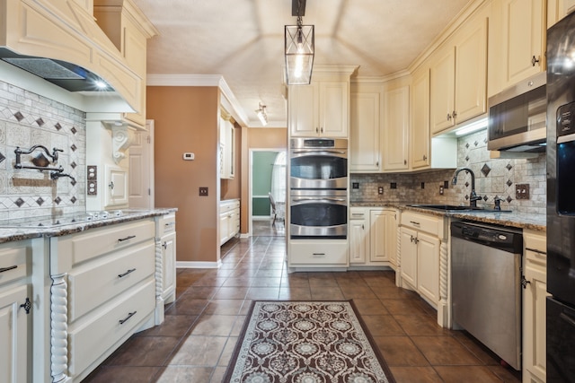 kitchen with appliances with stainless steel finishes, sink, pendant lighting, light stone counters, and decorative backsplash