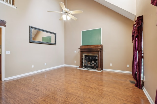 unfurnished living room with light wood-type flooring, high vaulted ceiling, and ceiling fan