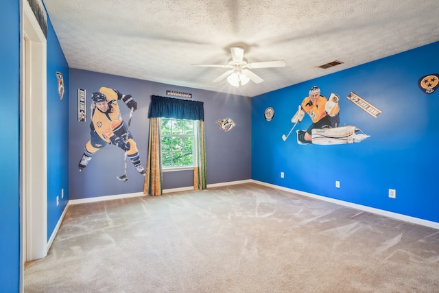 spare room with a textured ceiling, carpet flooring, and ceiling fan