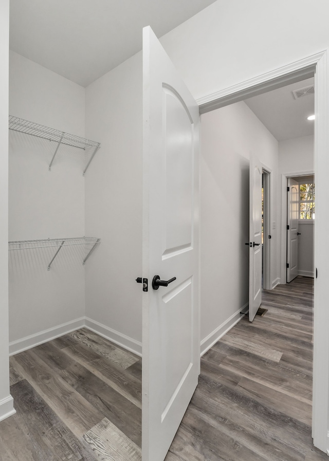 spacious closet with dark wood-type flooring