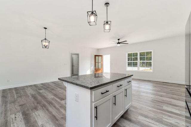 kitchen featuring light hardwood / wood-style flooring, white cabinetry, a center island, and decorative light fixtures