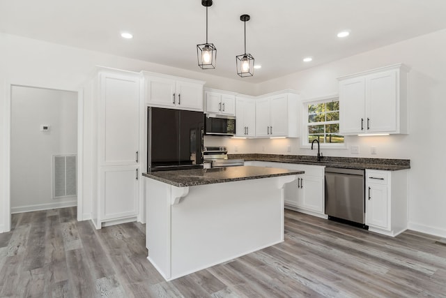 kitchen featuring light hardwood / wood-style flooring, sink, a center island, white cabinets, and appliances with stainless steel finishes