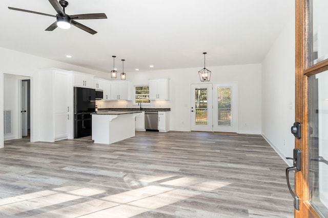 kitchen featuring light hardwood / wood-style flooring, white cabinets, a center island, and stainless steel appliances