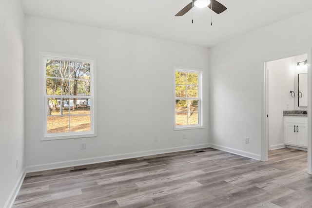 unfurnished room with light hardwood / wood-style floors, a healthy amount of sunlight, and ceiling fan