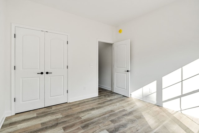 unfurnished bedroom featuring a closet and light hardwood / wood-style floors