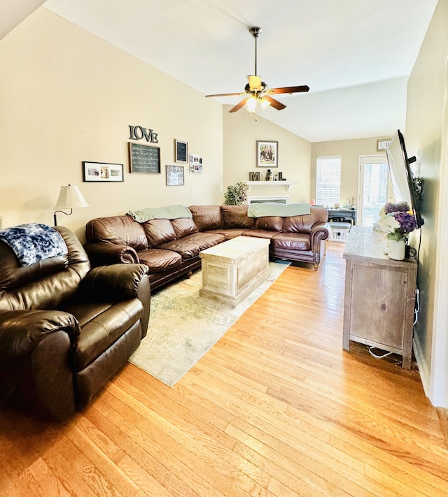 living room with lofted ceiling, ceiling fan, and light hardwood / wood-style flooring