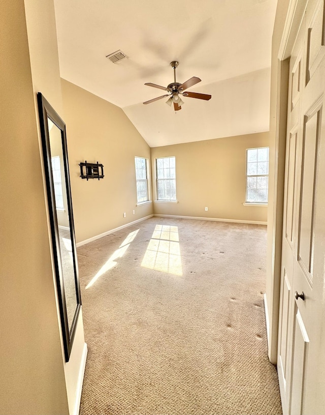 unfurnished room with vaulted ceiling, light colored carpet, and ceiling fan