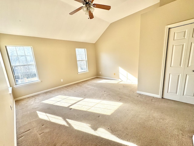 unfurnished room with lofted ceiling, light carpet, and ceiling fan