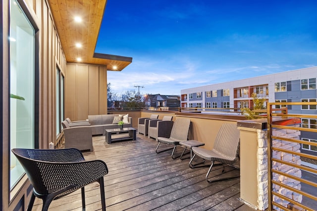 deck at dusk featuring an outdoor hangout area