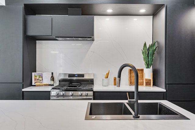 kitchen featuring sink, stainless steel gas stove, and tasteful backsplash