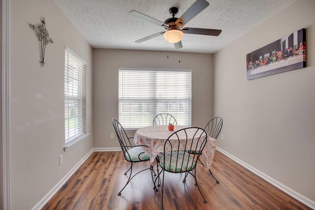 dining room featuring a textured ceiling, hardwood / wood-style flooring, ceiling fan, and a wealth of natural light