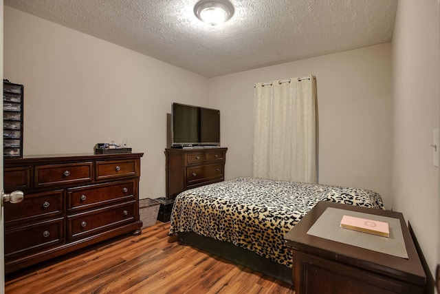 bedroom featuring dark hardwood / wood-style floors and a textured ceiling