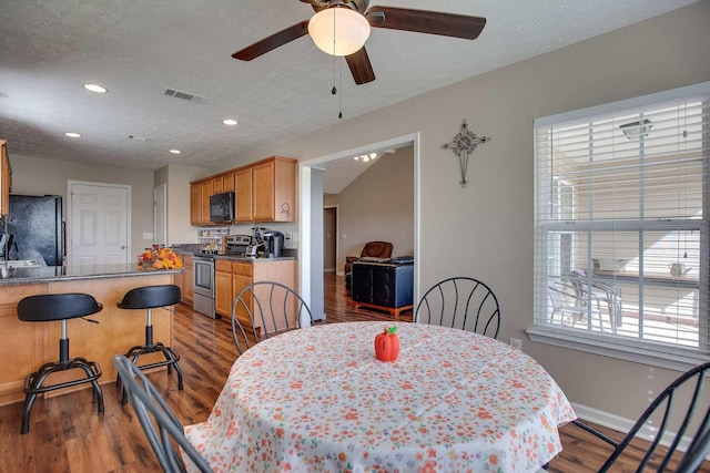 dining room featuring a textured ceiling, hardwood / wood-style flooring, and ceiling fan